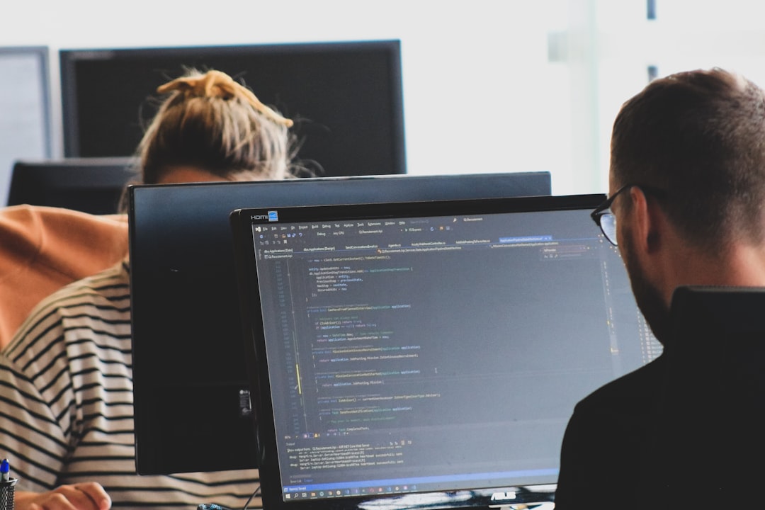 woman-in-black-shirt-sitting-beside-black-flat-screen-computer-monitor-im-cq6hqo10